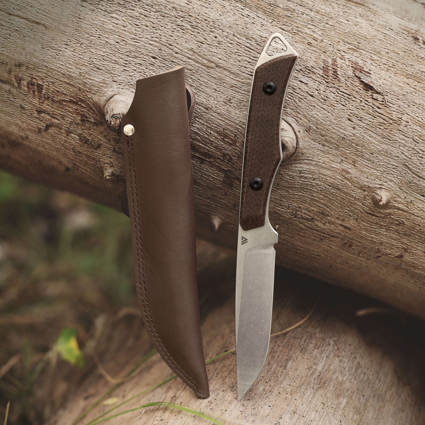 Knife with leather sheath on a wooden surface