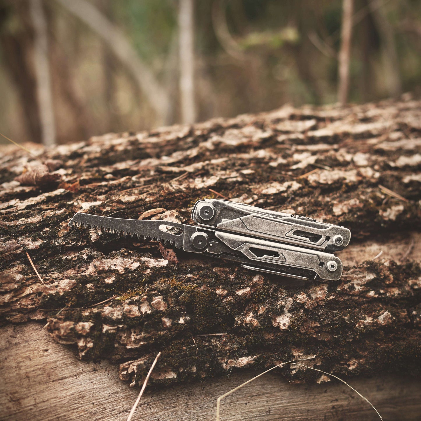 Multitool on a wooden log with a blurred natural background