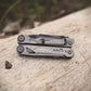 Multitool on a wooden surface with a blurred natural background