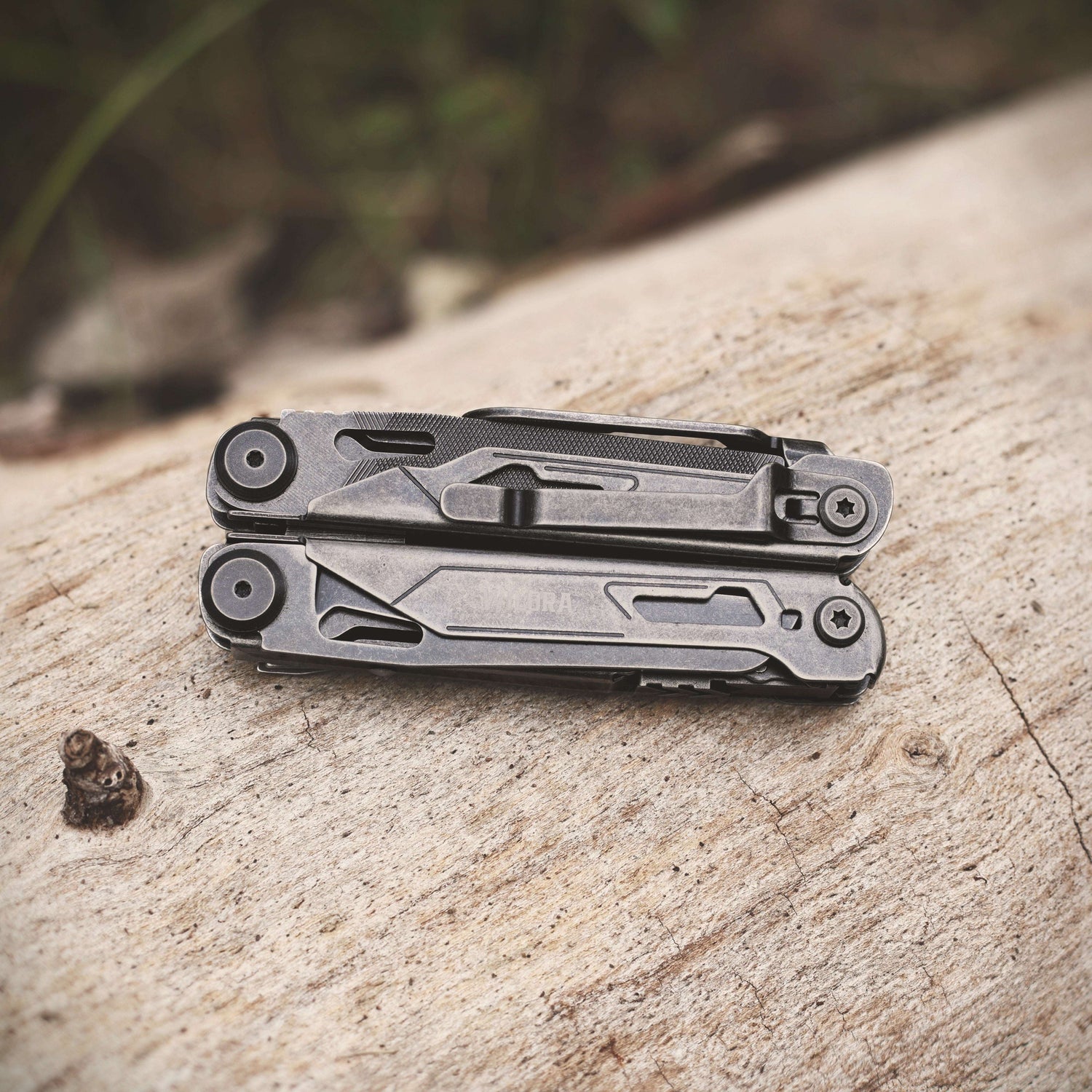 Multitool on a wooden surface with a blurred natural background