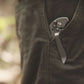 Folding knife in a pocket with a blurred natural background