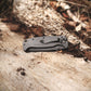 Folding knife on a wooden surface with natural background