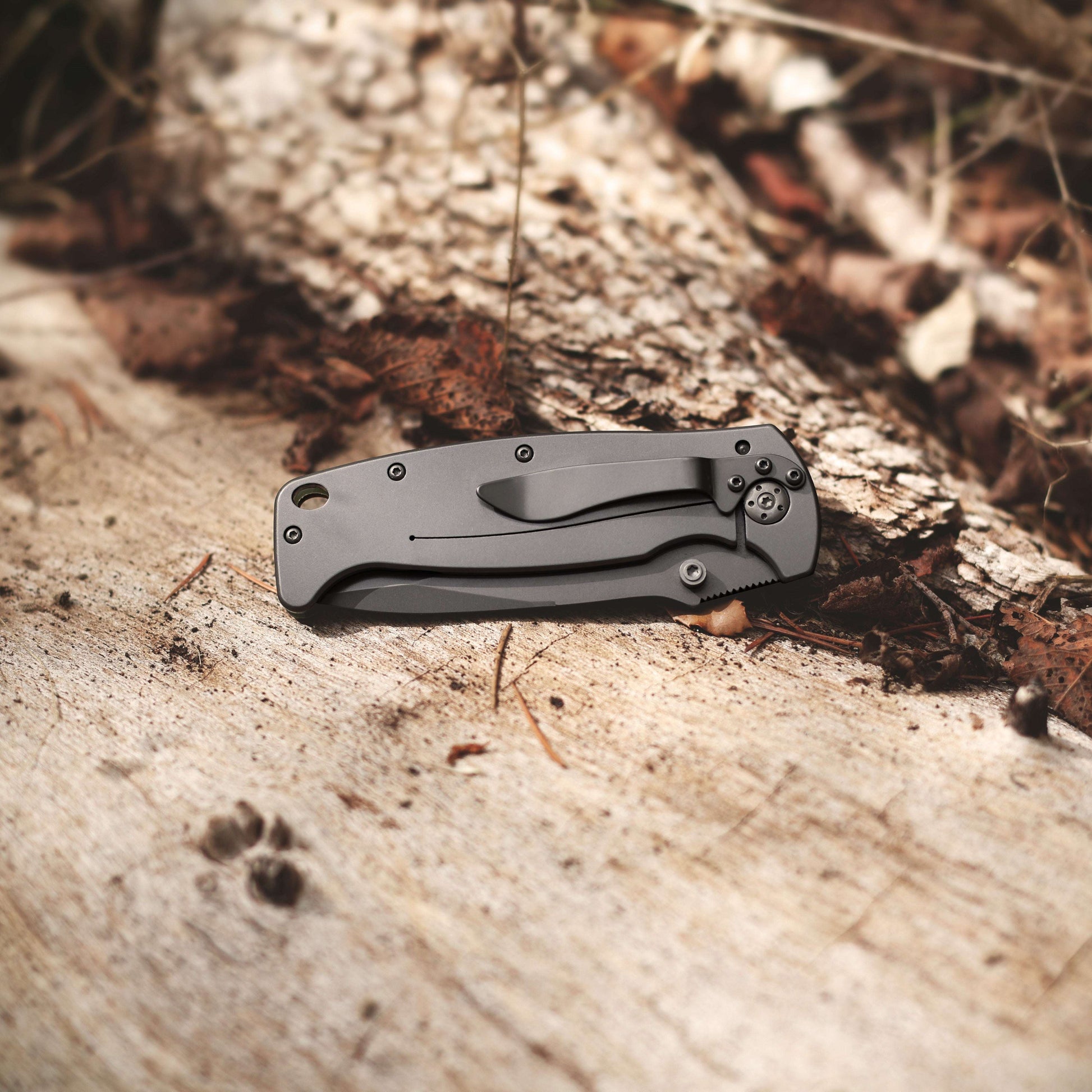 Folding knife on a wooden surface with natural background