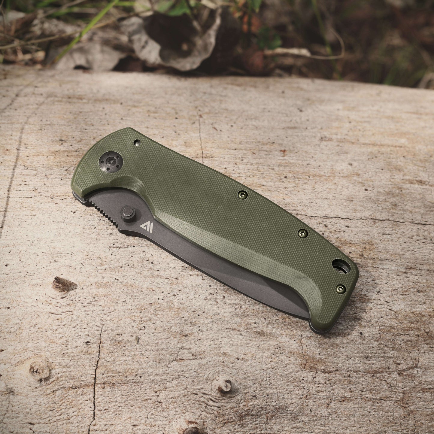 Green folding knife on a wooden surface with a natural background