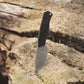Knife with a black handle on a textured stone surface