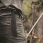 Person wearing a leather knife sheath on a blurred natural background