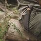 Leather knife sheath on a person's hip with a natural outdoor background