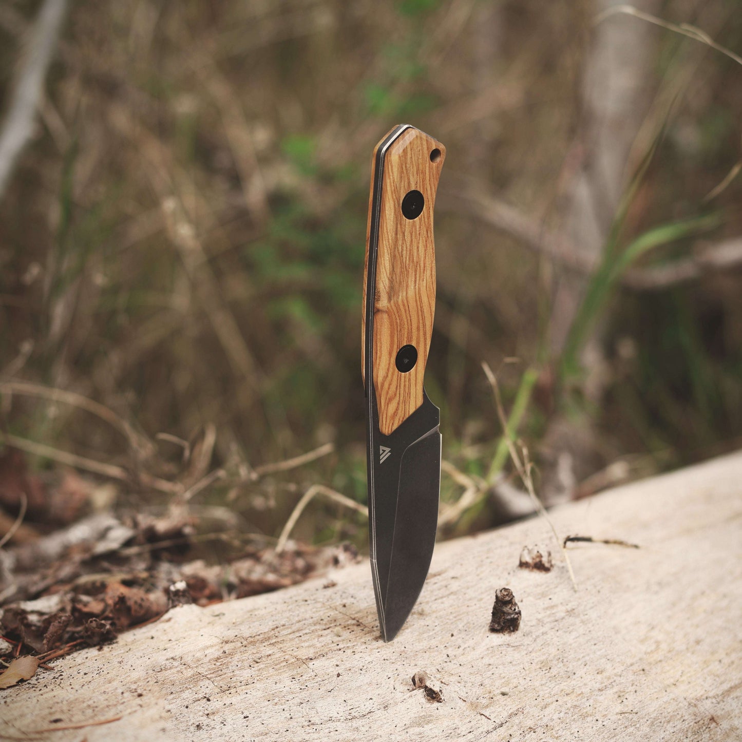 Knife with a wooden handle on a rock with a natural background
